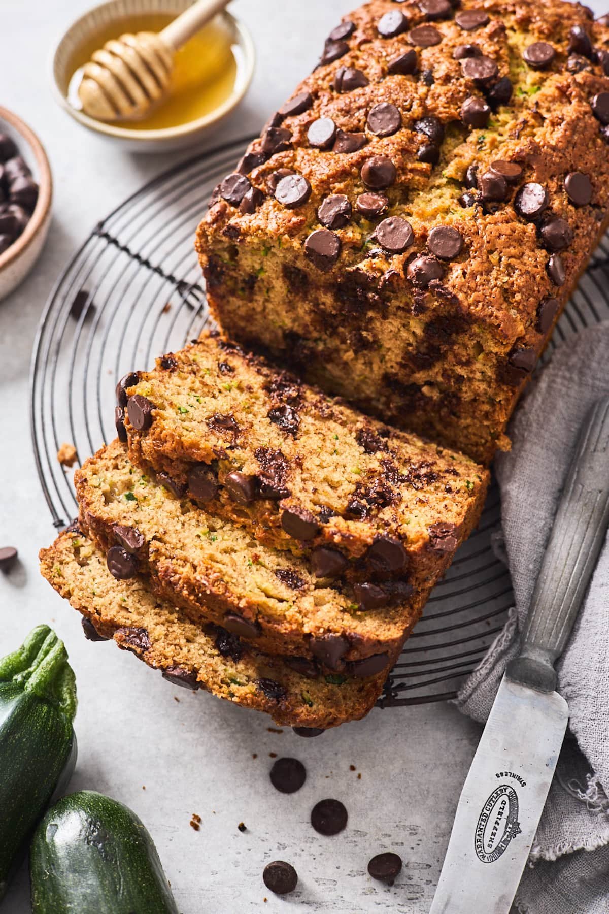healthy zucchini bread with chocolate chips cut into slices on cooling rack.