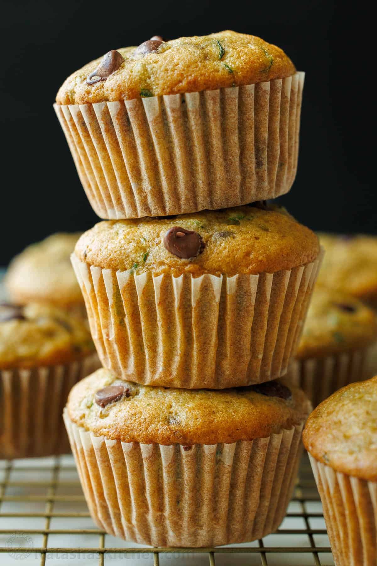 3 zucchini muffins stacked on cooling rack