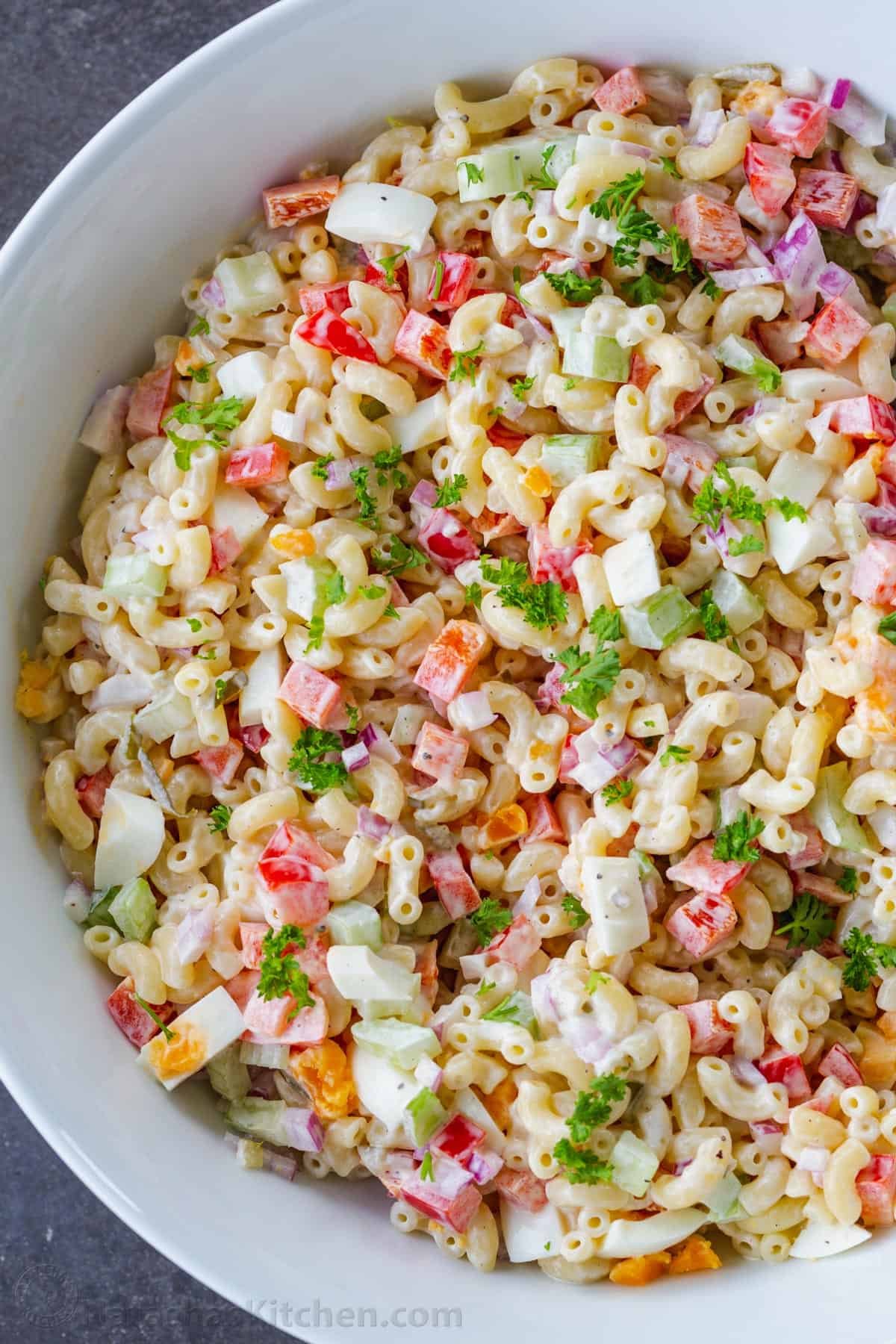 Macaroni Salad is perfect for a summer menu. Paired with BBQ meats, hot dogs, and hamburgers, it's the perfect creamy, refreshing side dish. Creamy macaroni salad recipe in bowl