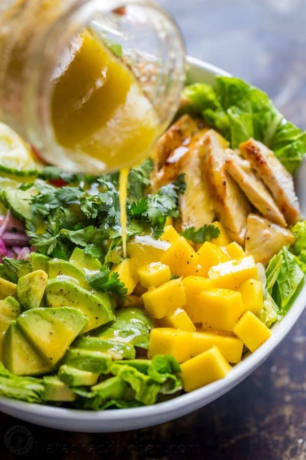 honey vinaigrette dressing pouring over chicken mango salad with same flavor profile as cheesecake factory recipe