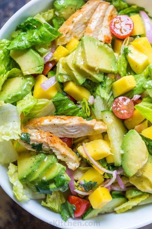 Tossed chicken mango avocado salad with honey vinaigrette with mango, seared chicken and sliced avocado
