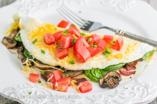 This fluffy egg white omelette is loaded with bacon, mushrooms, cheese, and fresh spinach which softens perfectly inside the omelette. So satisfying! | NatashasKitchen.com 