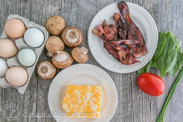 This fluffy egg white omelette is loaded with bacon, mushrooms, cheese, and fresh spinach which softens perfectly inside the omelette. So satisfying! | NatashasKitchen.com 
