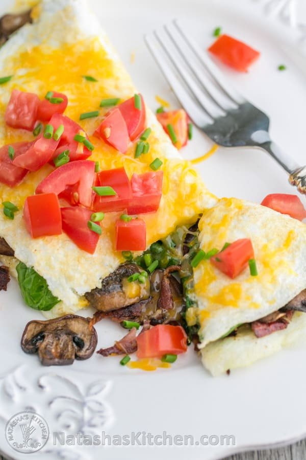 This fluffy egg white omelette is loaded with bacon, mushrooms, cheese, and fresh spinach which softens perfectly inside the omelette. So satisfying! | NatashasKitchen.com 