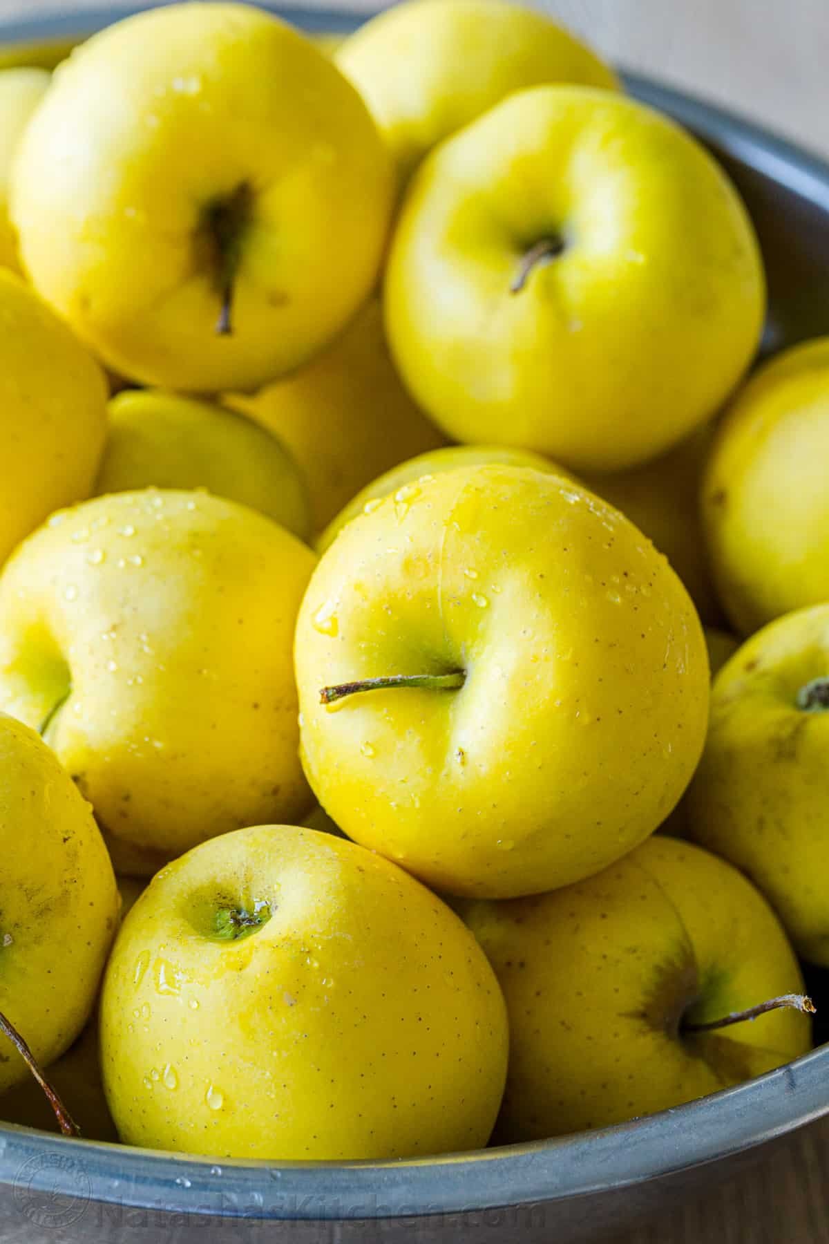 There's nothing like Homemade Applesauce with fresh apple flavor. Use very ripe apples and you don't even need to add sugar. How to make and can applesauce. #applesauce #applesaucerecipe #howtomakeapplesauce #apples #howtocanapplesauce #natashaskitchen #canningrecipes a photo of golden delicious apples after being washed