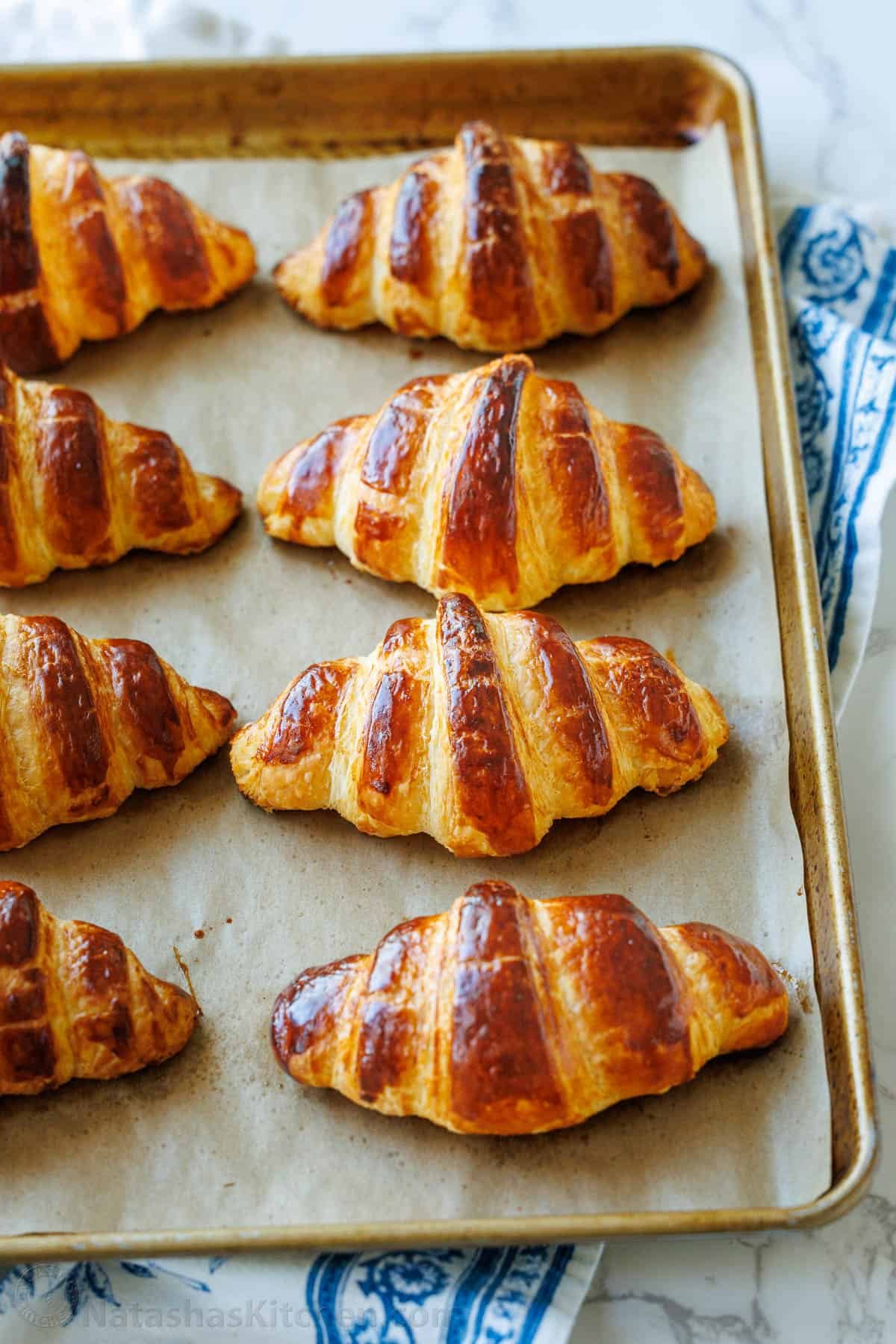 Freshly baked French croissant—crispy on the outside and soft on the inside. With tips from Paris, I've perfected this recipe and know you will love it! Croissants cooled on a baking sheet and ready for storing