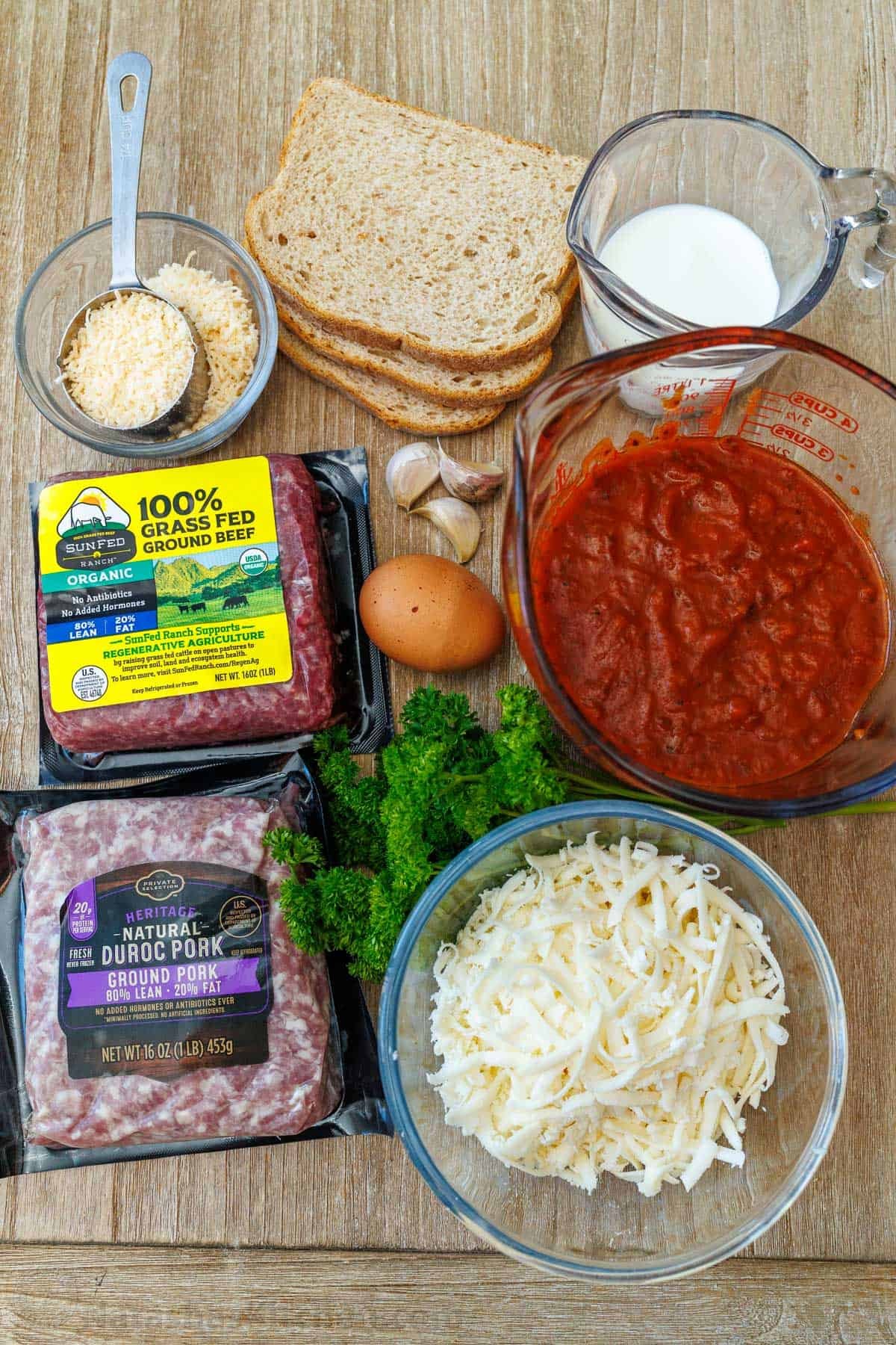 This Meatballs Parmesan Recipe combines the best Italian dishes into one, delicious and easy dish. Homemade Meatballs ready in just an hour! Ingredients for making homemade meat ball parm including ground beef, ground pork, egg, garlic, bread, cheese, parsley, and marinara sauce.