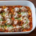 Meatballs Parmesan Casserole in a white dish with cheese and parmesan on top.