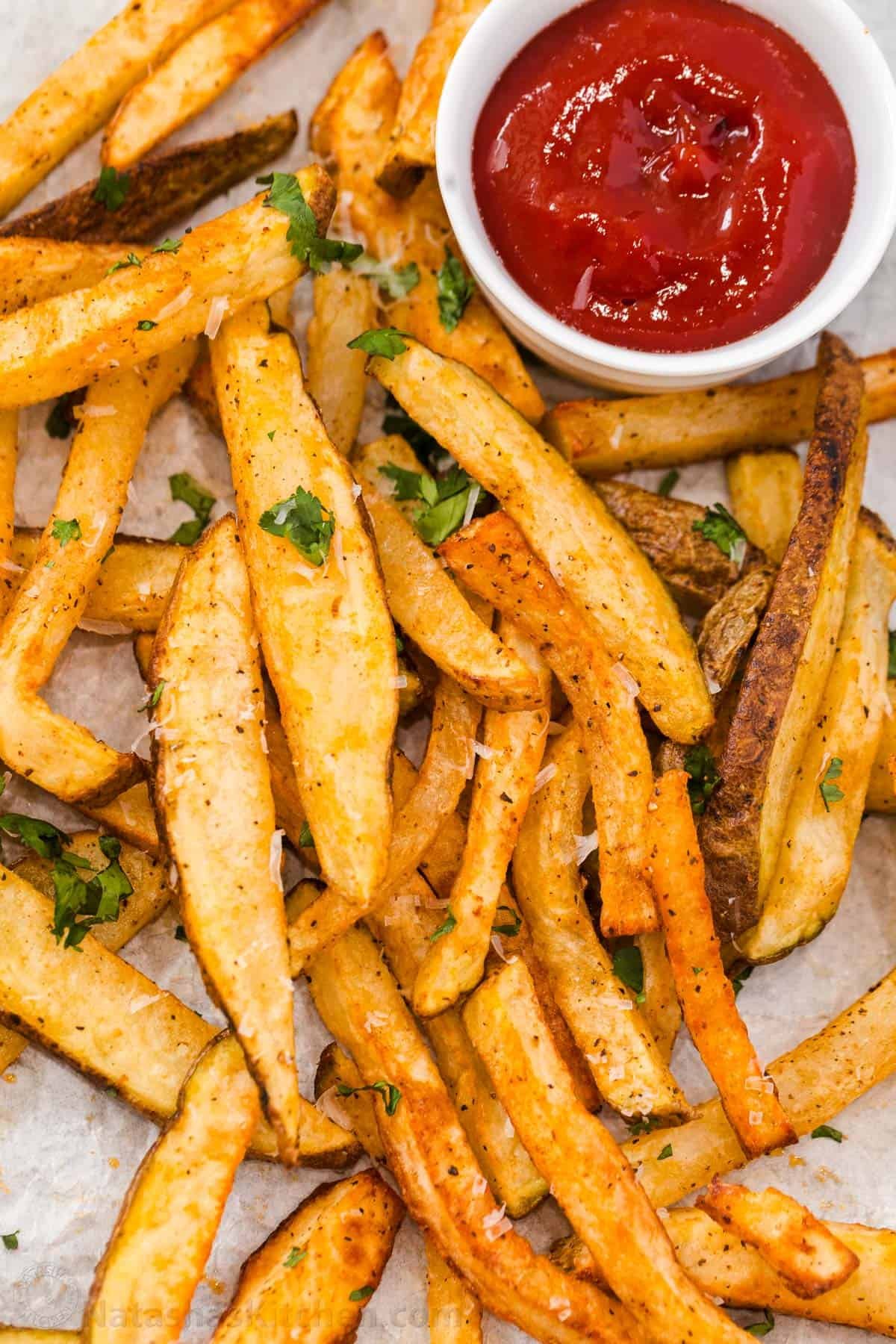 Homemade Air Fryer French Fries are so easy to make and taste much better than frozen fries! The Air Fryer makes it quick and easy to serve. Homemade French Fries in the air fryer on a platter with ketchup on the side
