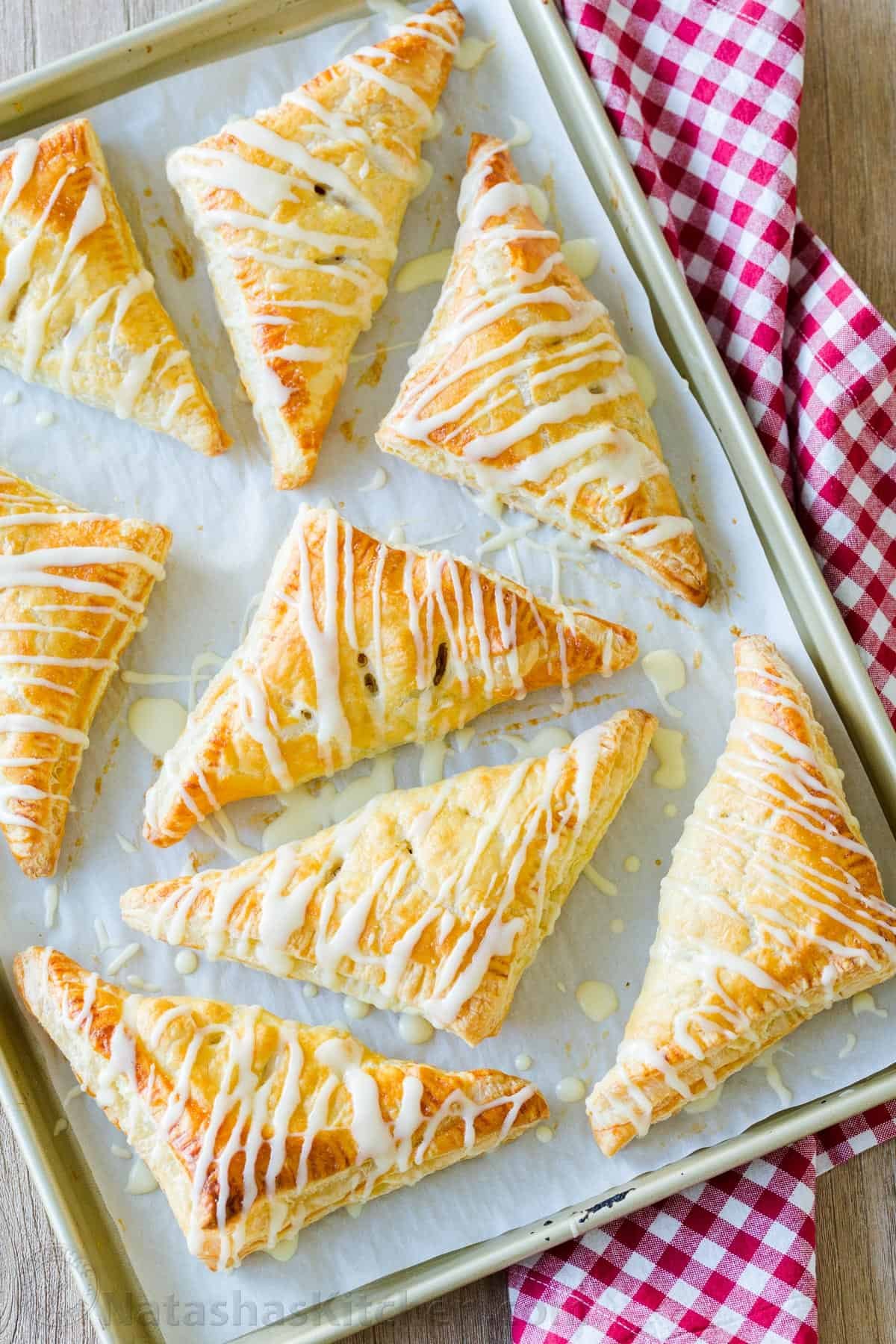 Baked apple turnovers on baking sheet without filling leaking out