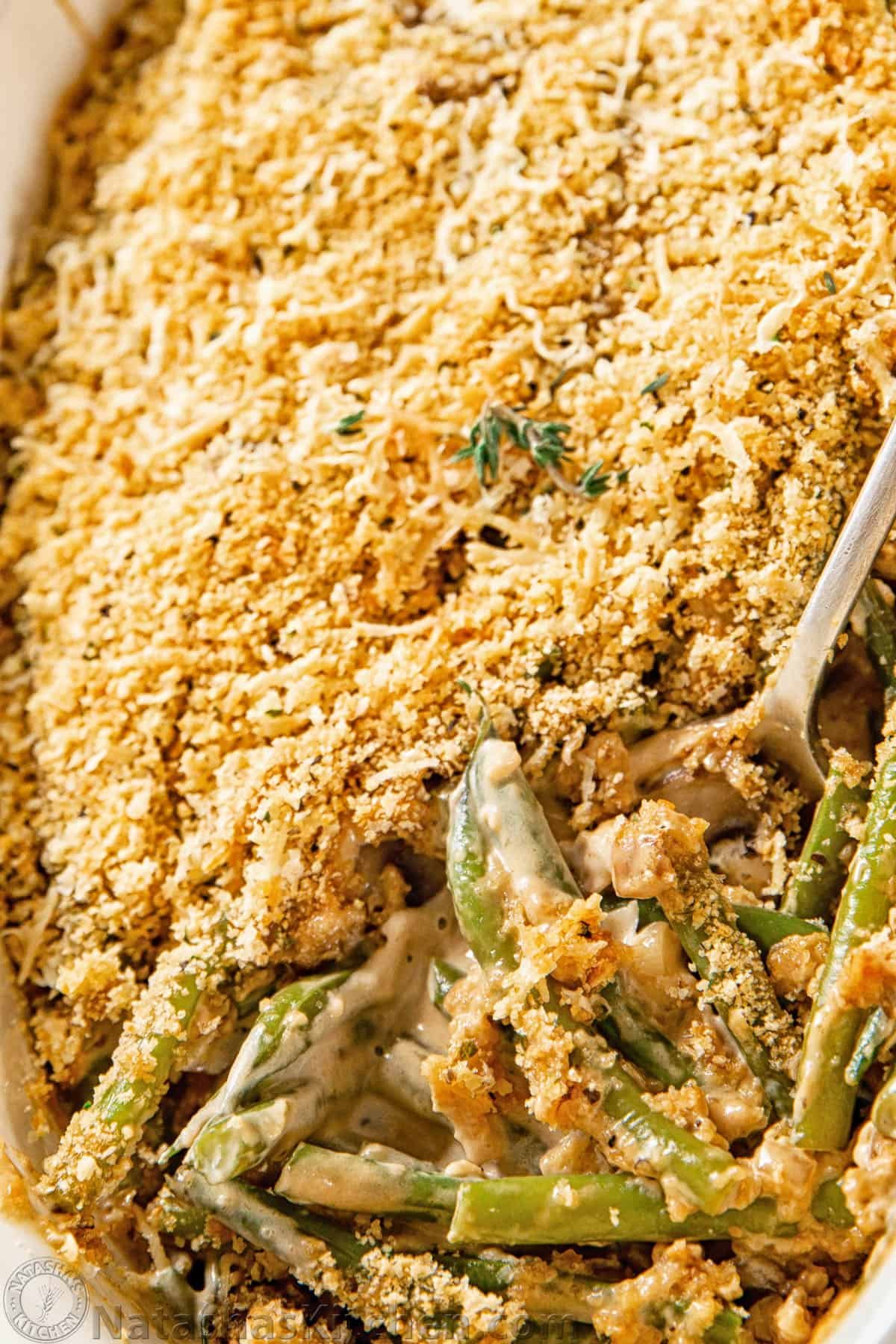 Green Bean Casserole (from scratch), with the best topping. This Thanksgiving side dish uses homemade cream of mushroom soup and it's a make-ahead recipe. #greenbeancasserole #greenbeancasserolefromscratch #healthy #sidedish #homemade How to make green bean casserole with close-up of Green Bean Casserole with a spoon