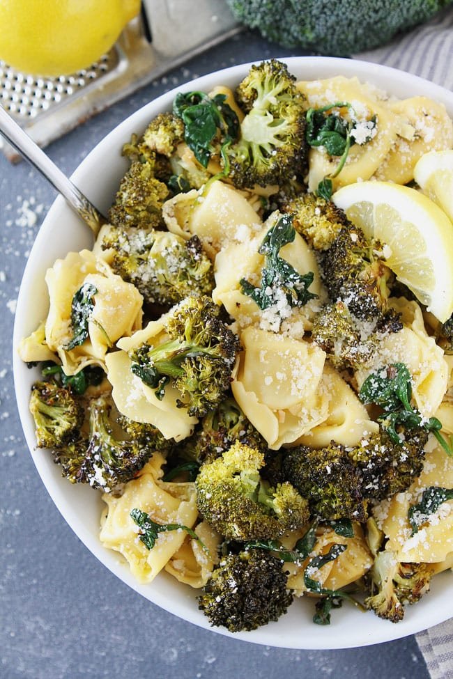 Lemon Broccoli Tortellini Recipe on twopeasandtheirpod.com Cheese tortellini with roasted broccoli, spinach, lemon, and parmesan cheese. This easy pasta dish is a favorite weeknight dinner. Easy Lemon Broccoli Tortellini with parmesan cheese in bowl