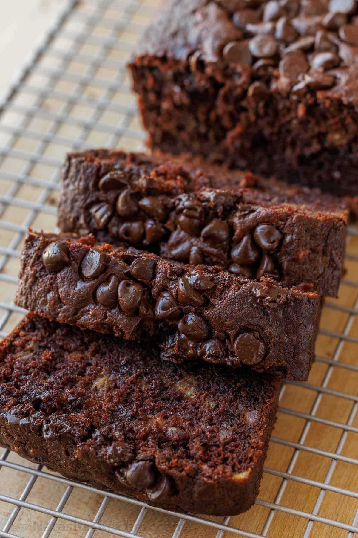 Our Chocolate Banana Bread is easy to make, extra chocolatey (with cocoa and chocolate chips), and stays moist for days. Chocolate Banana Bread topped with chocolate chips sliced on a wire rack