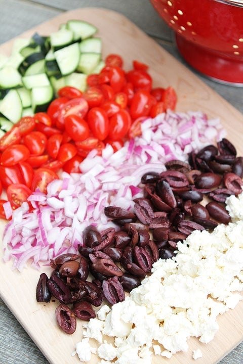 Greek Tortellini Pasta Salad Recipe on twopeasandtheirpod.com Greek Tortellini Pasta Salad Ingredients laid out on cutting board