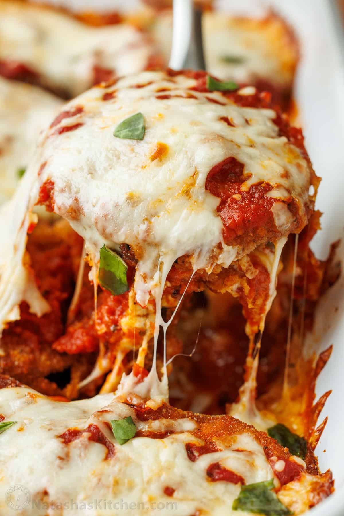 Eggplant Parmesan: Crispy breaded eggplant, layered with marinara sauce and mozzarella cheese, baked to perfection into a saucy and cheesy casserole. Mozzarella cheese pulls on Eggplant Parmesan as it is scooped out of the baking dish