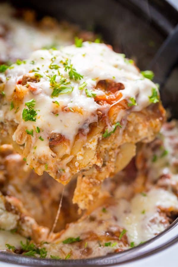 Slice of crockpot lasagna garnished  with parsley
