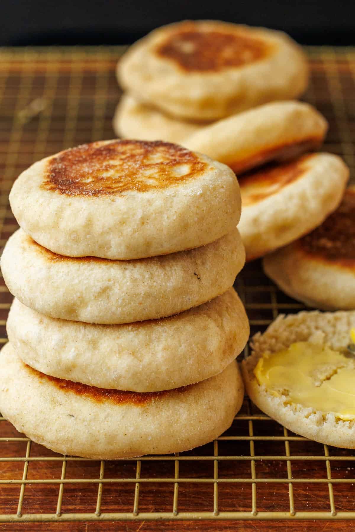 fresh english muffin recipe stacked on a cooling rack with butter