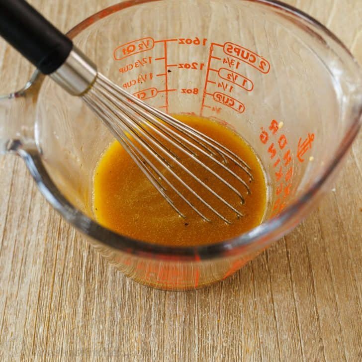 How to whisk salad dressing Honey vinaigrette in a mixing cup with a whisk
