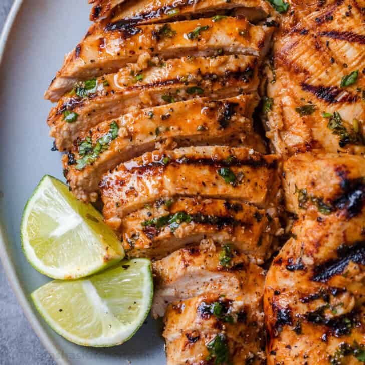 Cilantro Lime Chicken sliced on a plate served with lime wedges