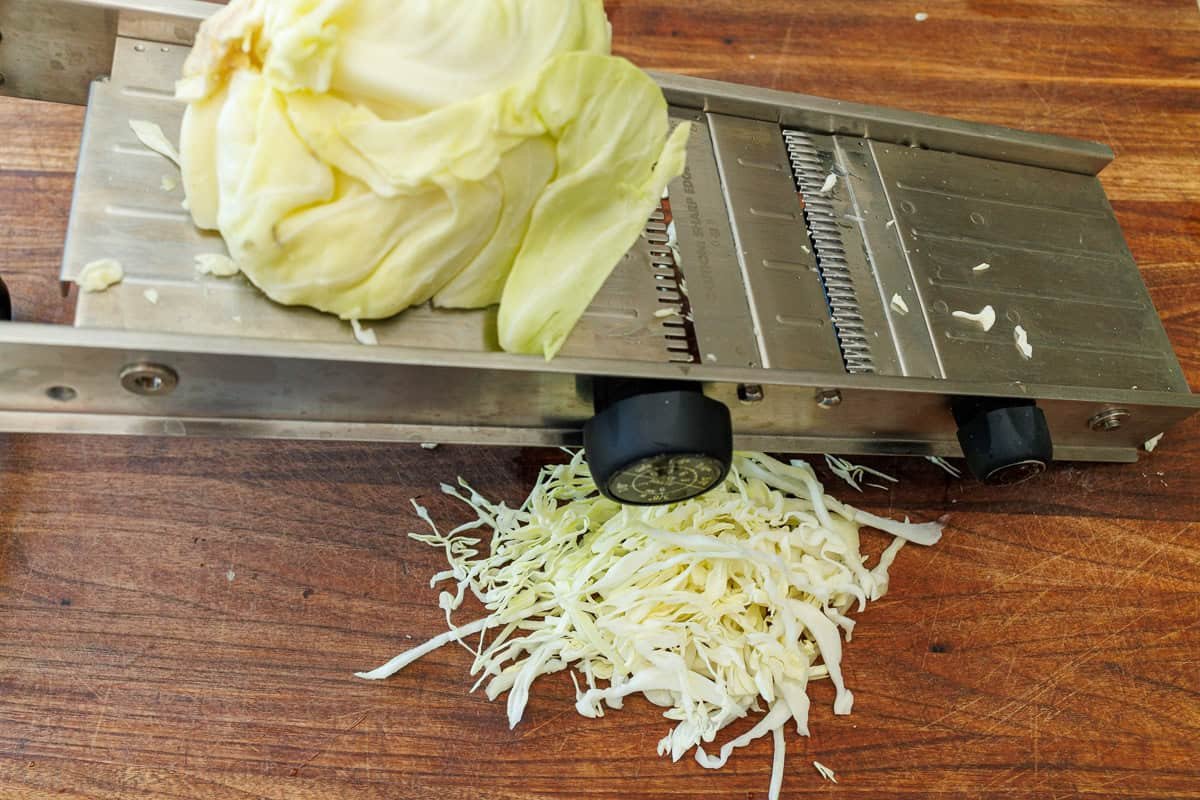 shredding cabbage on a mandolin slicer
