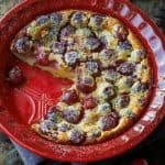 Cherry Clafoutis in a red dish with powdered sugar