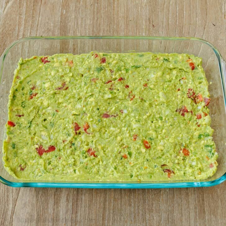 Guacamole layered in a glass pan for 7-Layer Dip