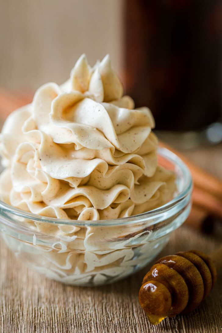 Flavored butter in ramekin with honey stick 