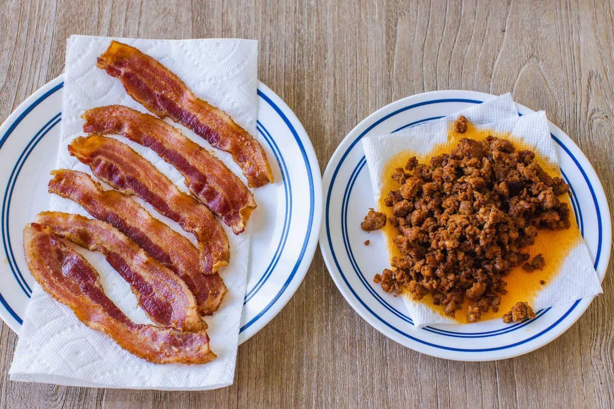 Cooked slices of bacon and chorizo mince on two plates lined with paper towels.