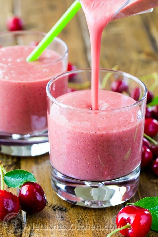A close up two glasses with strawberry and cherry smoothies 