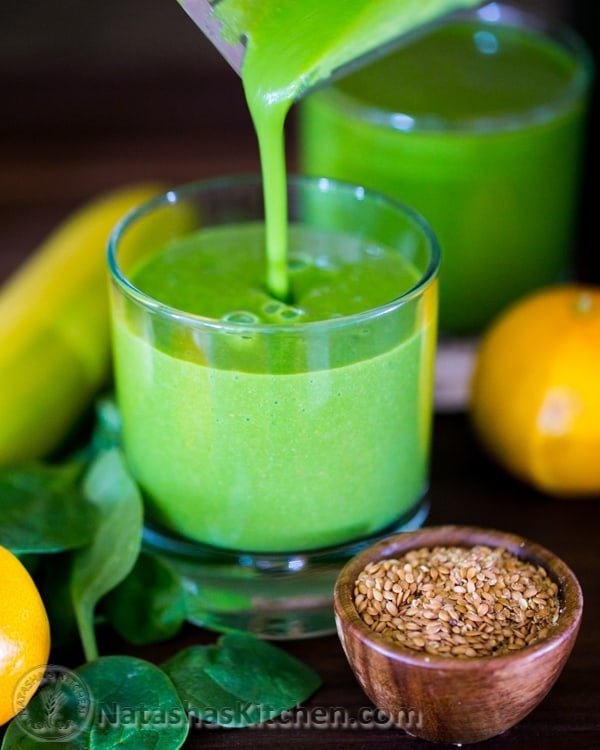 Green flax smoothie pouring into a cup