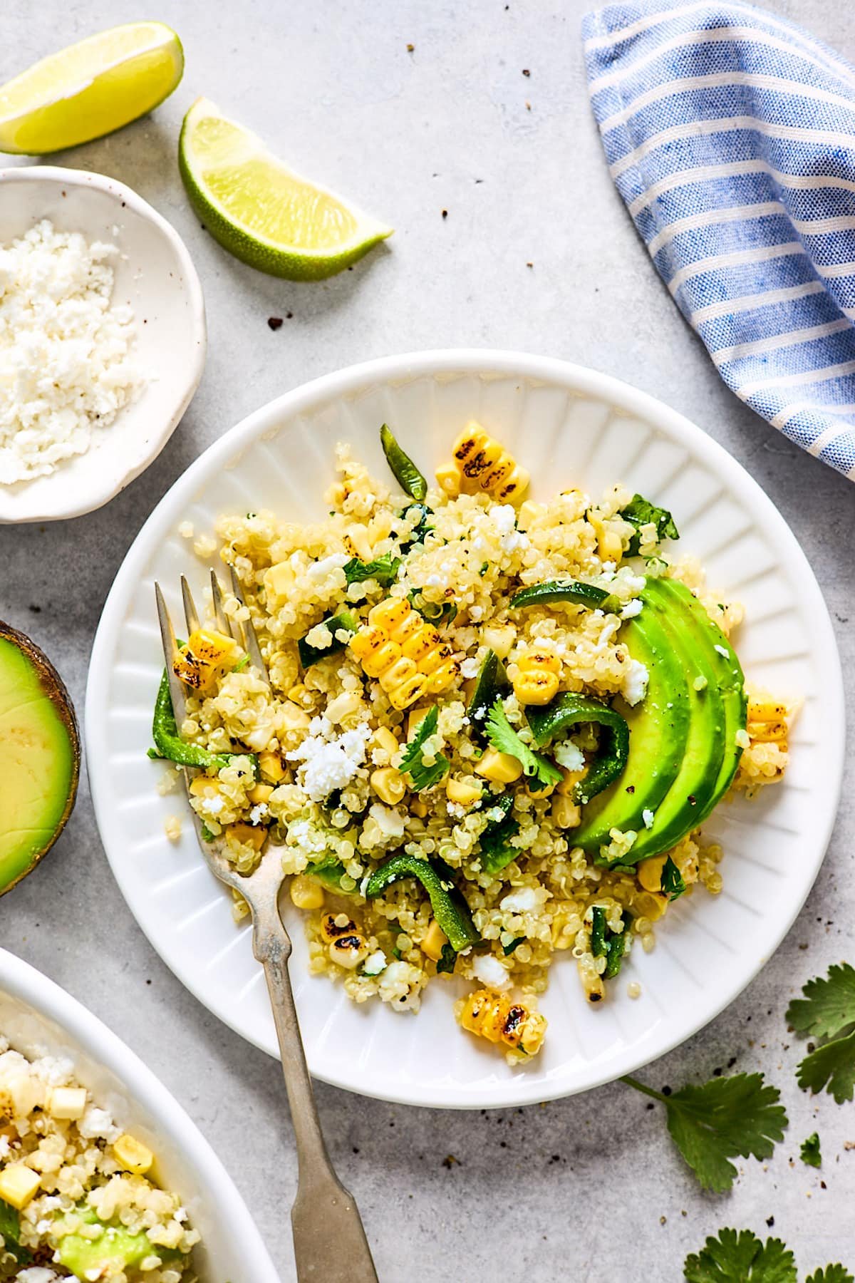 corn avocado quinoa salad on plate with fork. 