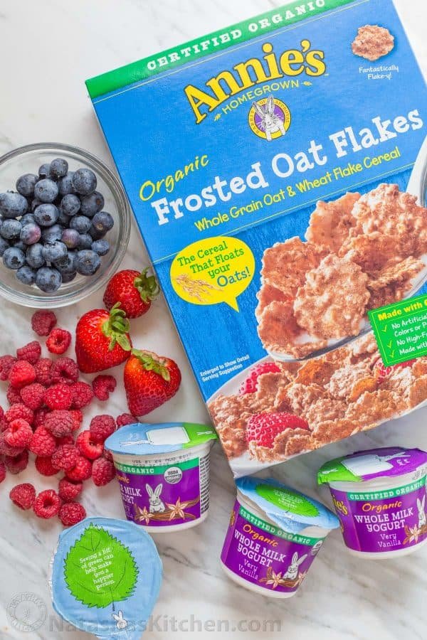 Frosted oat flakes, yogurt, strawberries, raspberries and blueberries on a table 