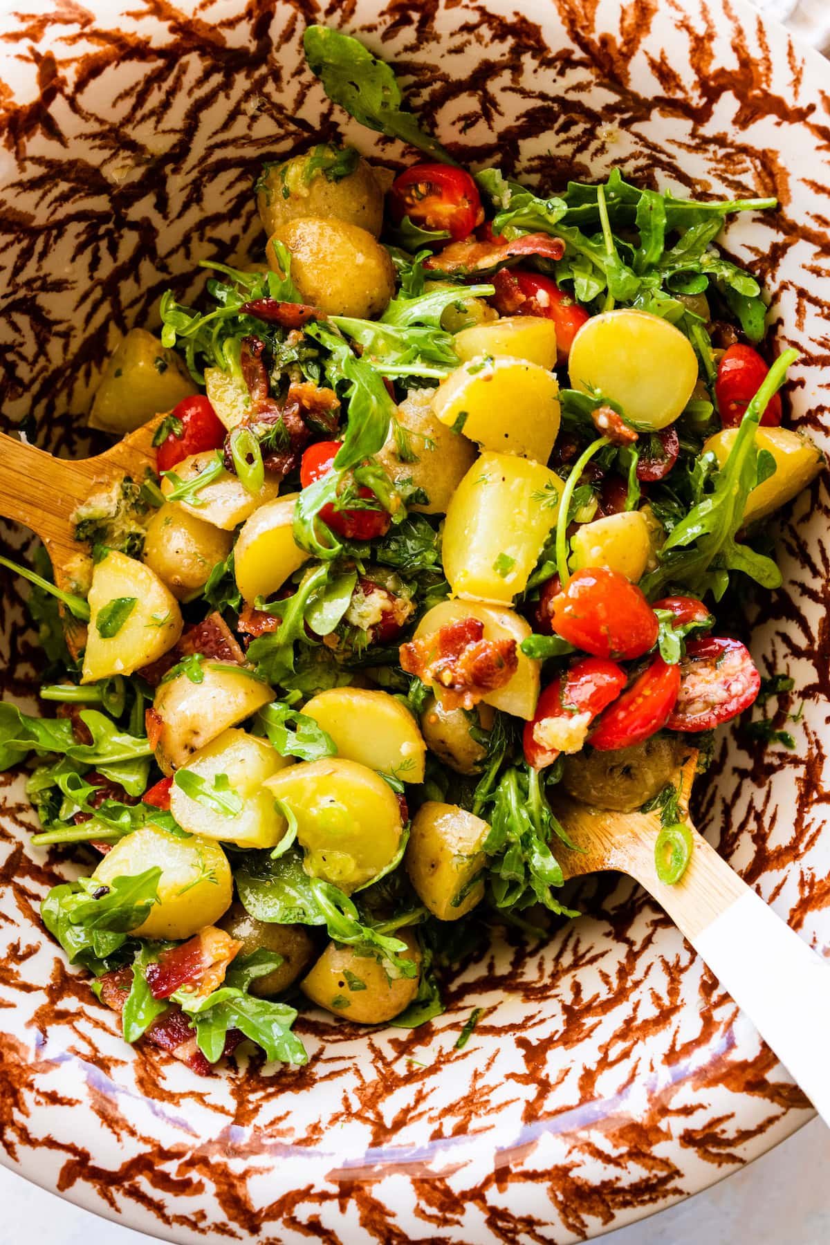 no mayo potato salad in bowl with salad servers. 