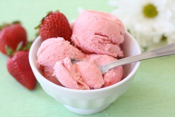 Strawberry Sour Cream Ice Cream Recipe on twopeasandtheirpod.com A must make ice cream for spring and summer! Strawberry Sour Cream Ice Cream in a bowl with a spoon