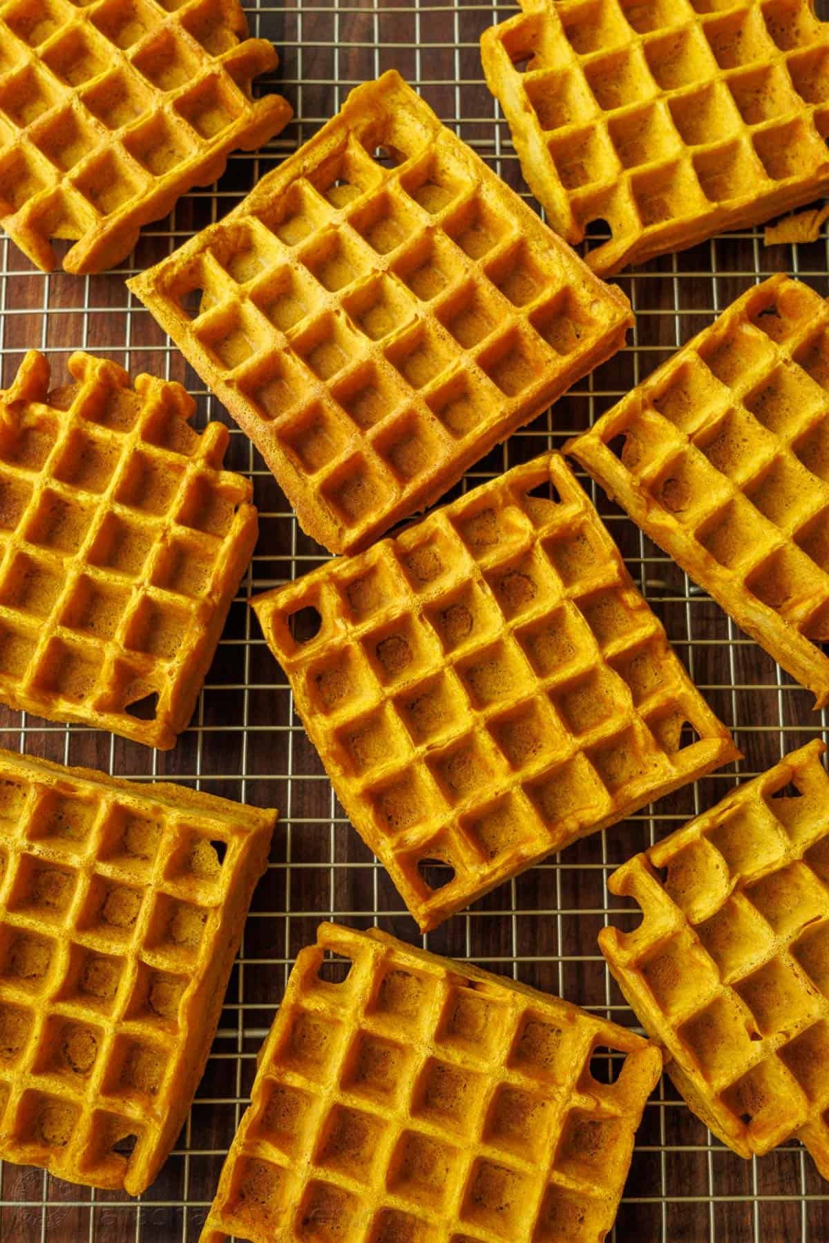 Pumpkin waffles made ahead and cooling on a wire cooling rack