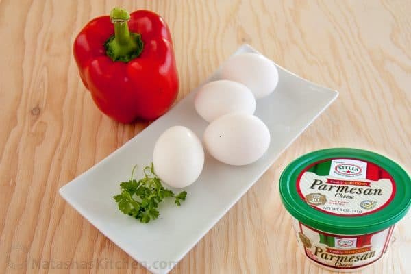A red pepper, 4 eggs and parmesan cheese on the table 