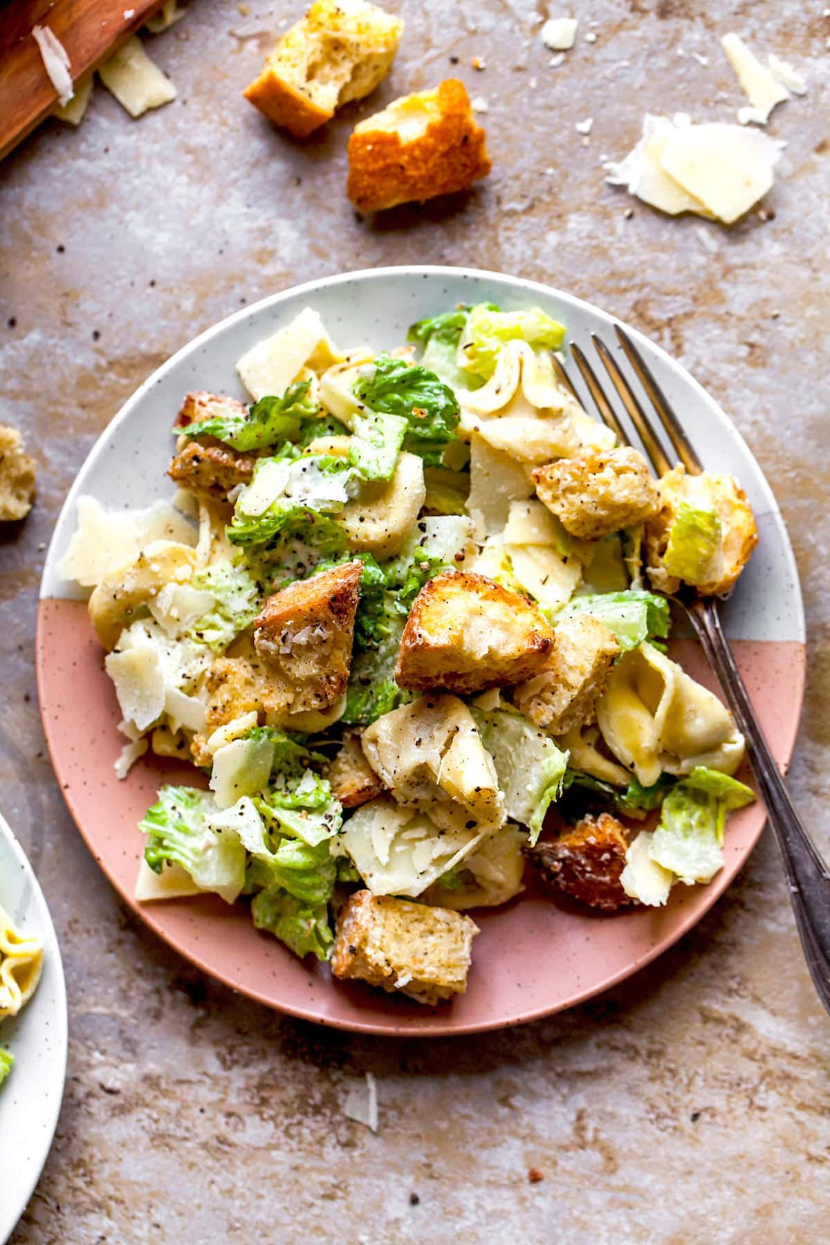 Caesar Salad with Tortellini on plate with fork.