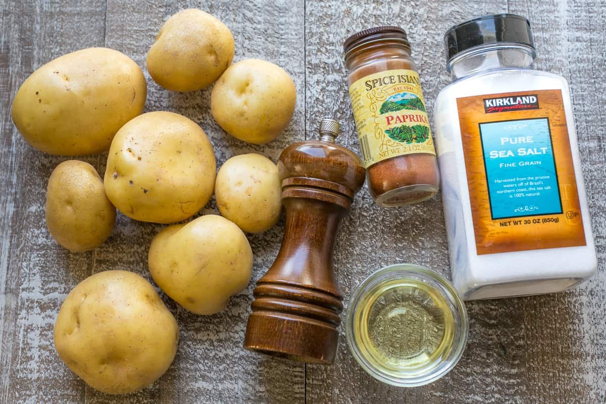 Our go-to, easy breakfast potatoes recipe uses simple ingredients and the best cooking method for potatoes, so each bite is delicious! ingredients for hashbrowns on a sheetpan including Yukon Golds, pepper, paprika, salt and olive oil