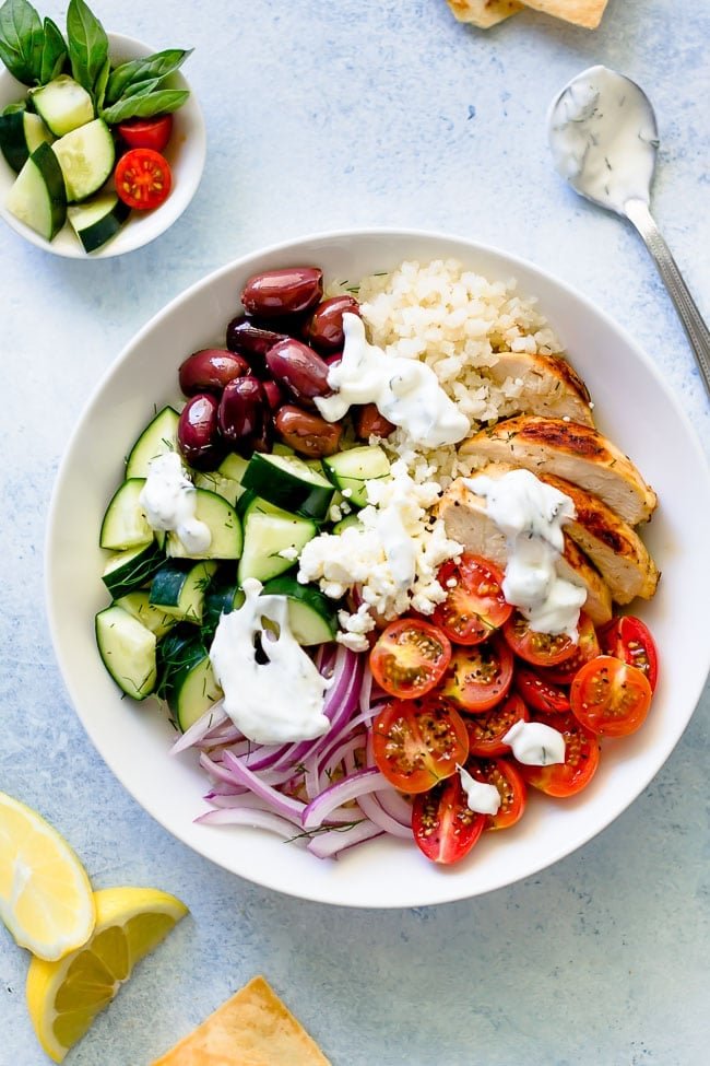 Greek Chicken Bowls Are Made With Lemon Oregano Chicken, Rice, Tomatoes, Cucumber, Olives, Feta Cheese, Red Onion, Fresh Herbs, And Finished With Tzatziki Sauce. These Healthy Bowls Are Great For Lunch Or Dinner. #chicken #chickendinner #dinner #bowls #Greek #healthyrecipe #chickenrecipe #rice #easyrecipe #mealprep Easy Greek Chicken Bowls