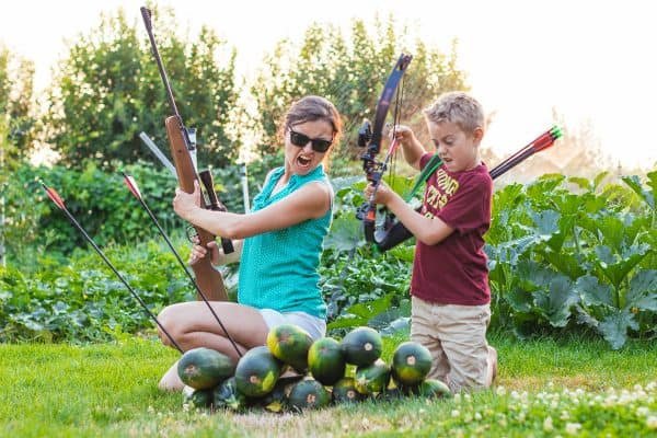 Natasha and her son making silly faces while collecting zucchini