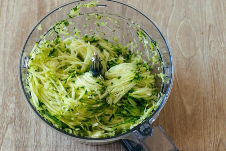These crispy homemade zucchini fritters are a kid-friendly family favorite. An easy summer zucchini recipe you'll make again and again. Shredded zucchini in food processor