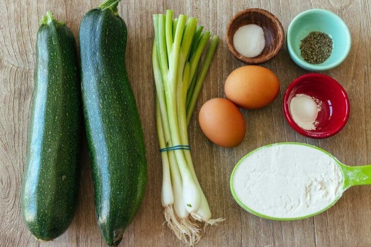 These crispy homemade zucchini fritters are a kid-friendly family favorite. An easy summer zucchini recipe you'll make again and again. Overhead view of ingredients for zucchini fritters