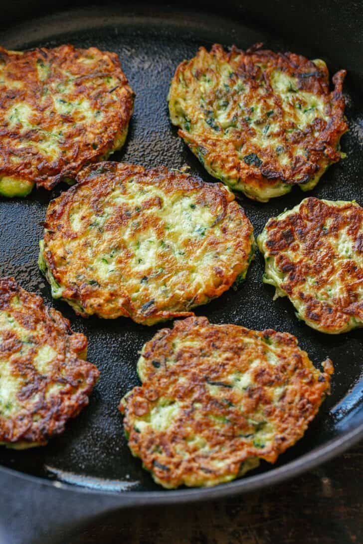 These crispy homemade zucchini fritters are a kid-friendly family favorite. An easy summer zucchini recipe you'll make again and again. Crispy zucchini fritters in cast iron skillet