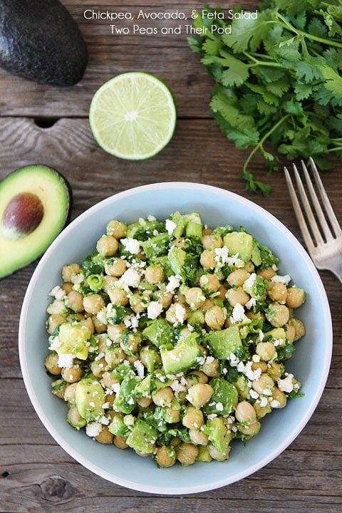 Chickpea, Avocado, & Feta Salad Recipe on twopeasandtheirpod.com Easy Chickpea, Avocado, & Feta Salad in blue bowl with avocado, lime, and cilantro.