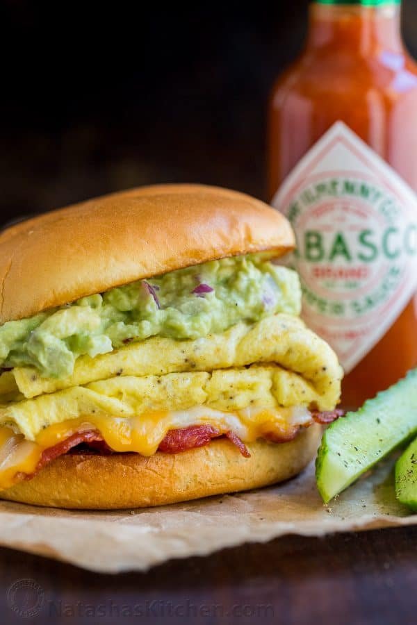 Spicy guacamole brunch sandwich with a crisp toasted bun, juicy sausage, melty cheese, fluffy eggs and guacamole! Easy guacamole breakfast sandwich! | natashaskitchen.com