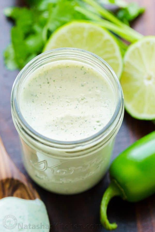 jalapeno ranch dressing in mason jar with jalapeno, limes and cilantro