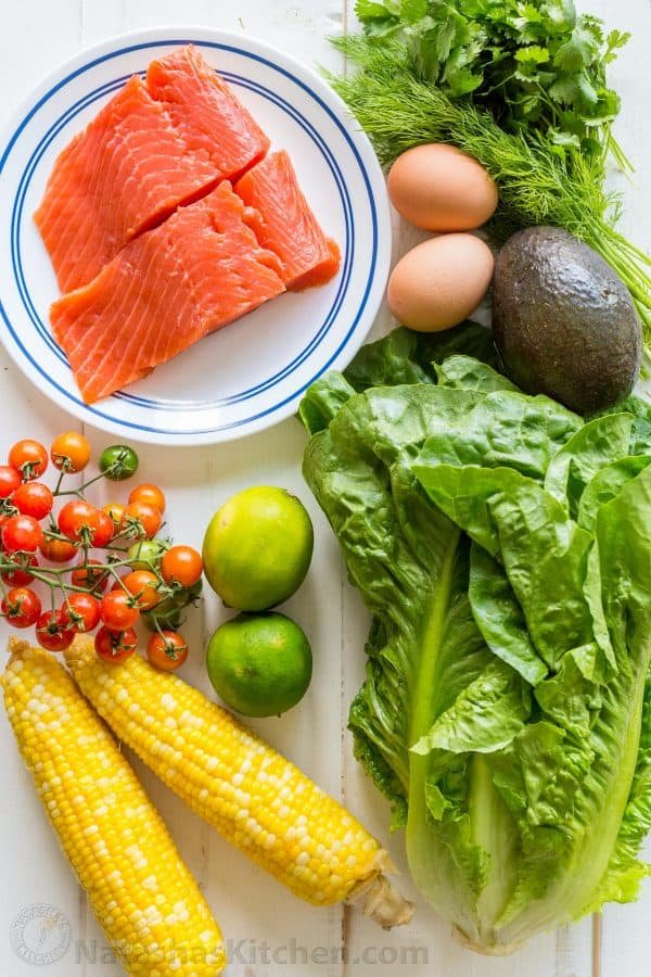 Ingredients for Cobb Salad with Salmon, avocado, lettuce, tomatoes, corn and cilantro lime dressing