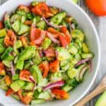 Cucumber tomato avocado salad in white serving bowl
