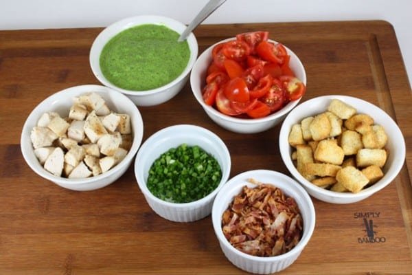 Ingredients in white bowls for creamy spinach salad with chicken and baby tomatoes 