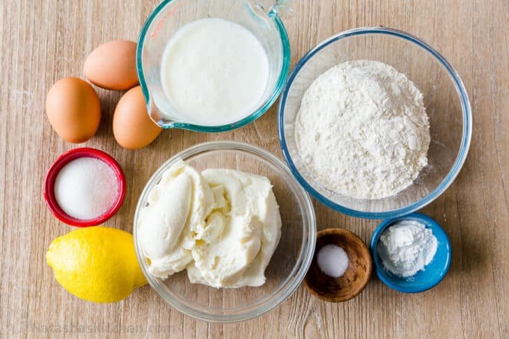 Ingredients for ricotta pancakes with ricotta cheese, buttermilk, flour, eggs, sugar, lemon, salt, sugar, and baking powder